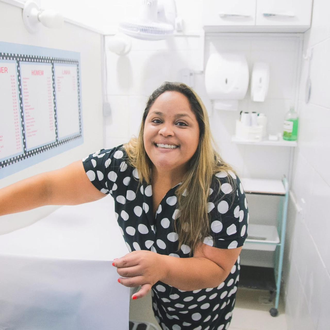 Marta Batista sorrindo na sala de atendimento da loja