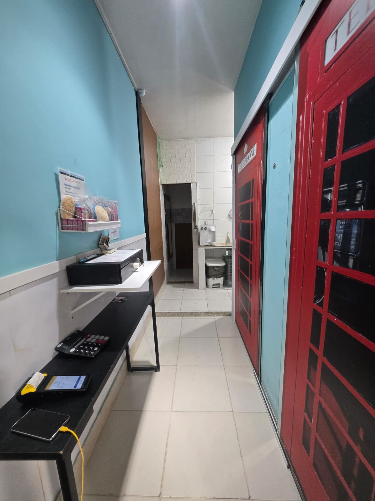 Corredor da loja com cabine telefônica vermelha estilo anos 80